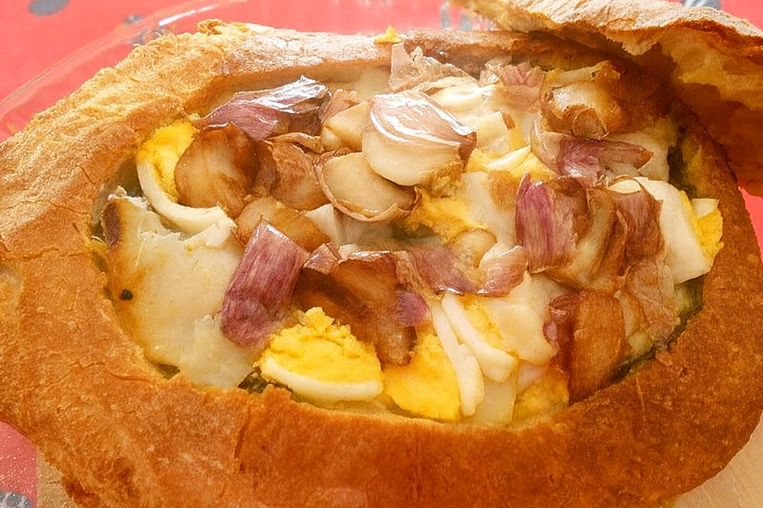 Pão recheado com bacalhau, couve e grão-de-bico, receita portuguesa tradicional e perfeita para partilhar.