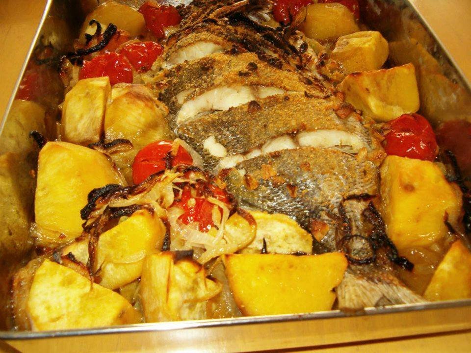 Peixe no forno com batatas, cebola e tomates cereja, prato tradicional português fácil e saboroso.